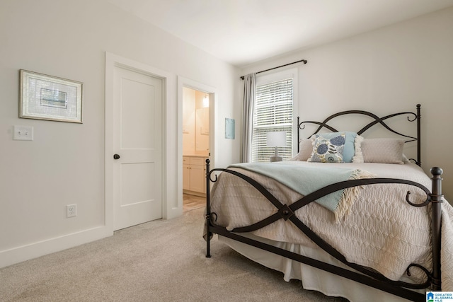 bedroom featuring light carpet, ensuite bathroom, and baseboards