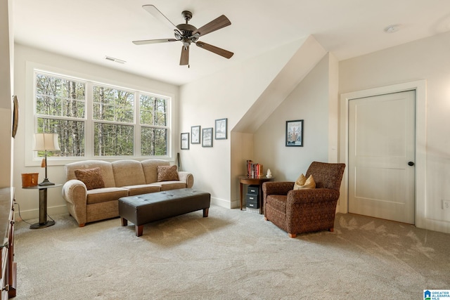 carpeted living area featuring ceiling fan, baseboards, and visible vents