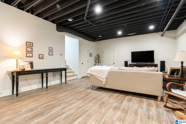 living area featuring light wood-type flooring and stairway