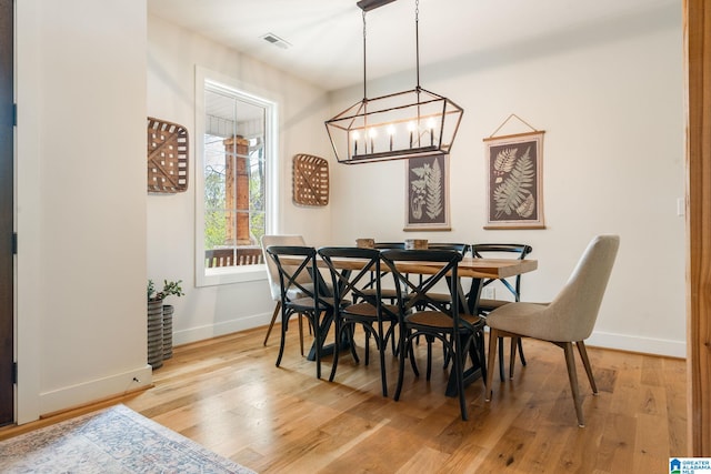 dining space with light wood-style flooring, baseboards, and visible vents