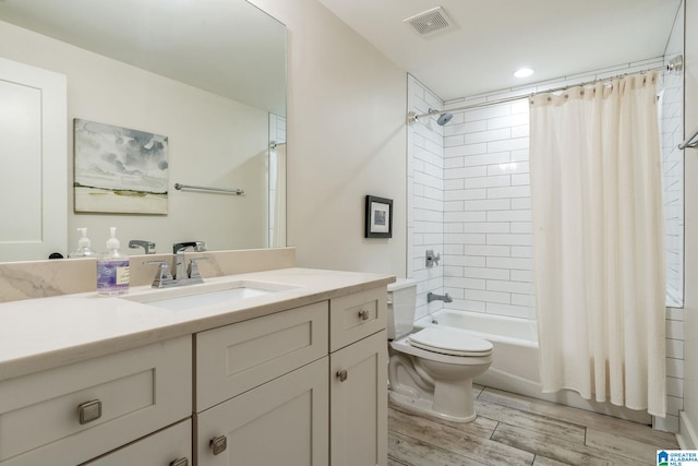full bathroom with vanity, visible vents, toilet, wood finished floors, and shower / tub combo