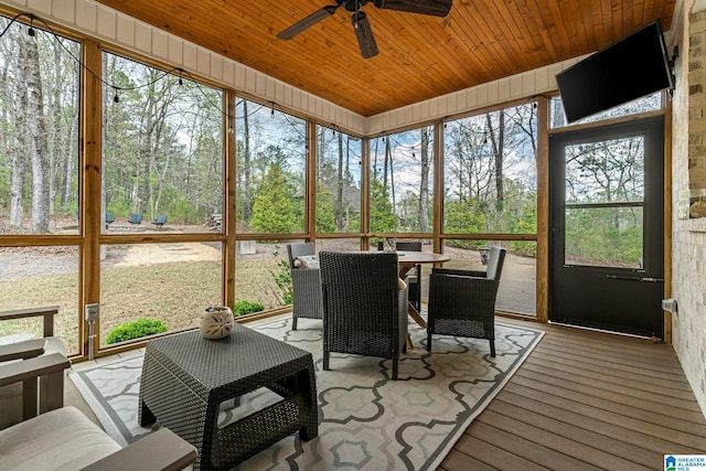 sunroom featuring outdoor dining space and a ceiling fan
