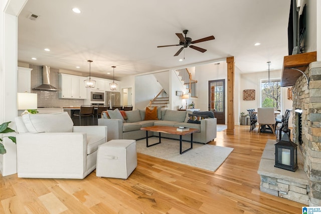 living room featuring recessed lighting, stairs, light wood-style flooring, and ceiling fan
