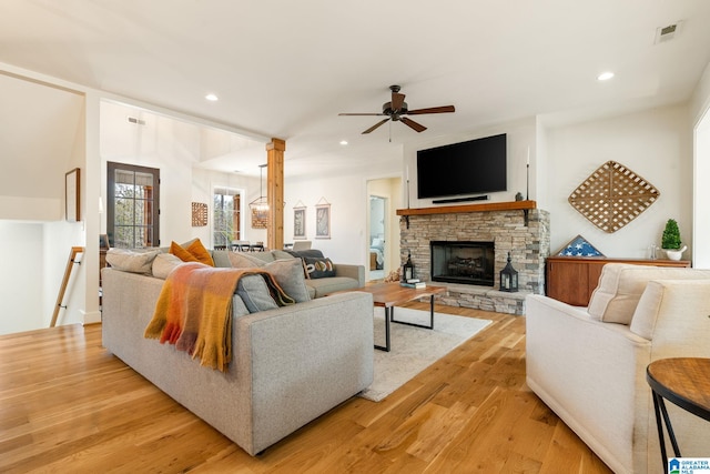 living room featuring decorative columns, light wood-type flooring, a ceiling fan, visible vents, and recessed lighting