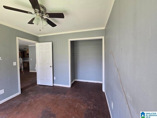 unfurnished bedroom featuring concrete floors, a closet, baseboards, crown molding, and a ceiling fan