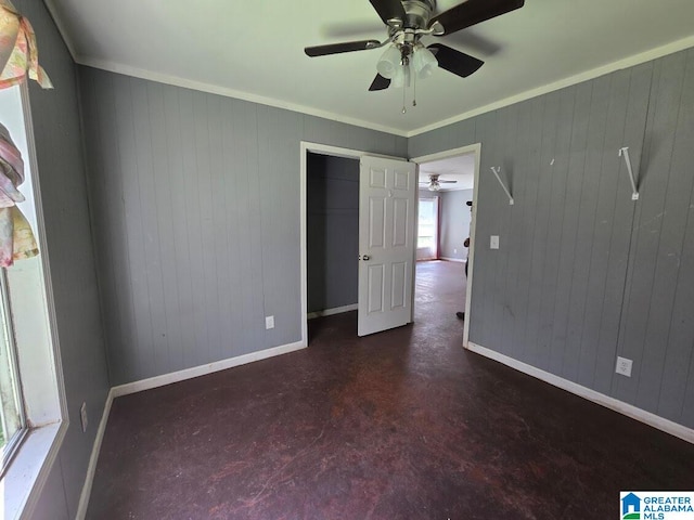 unfurnished bedroom featuring concrete flooring, ornamental molding, baseboards, and a ceiling fan