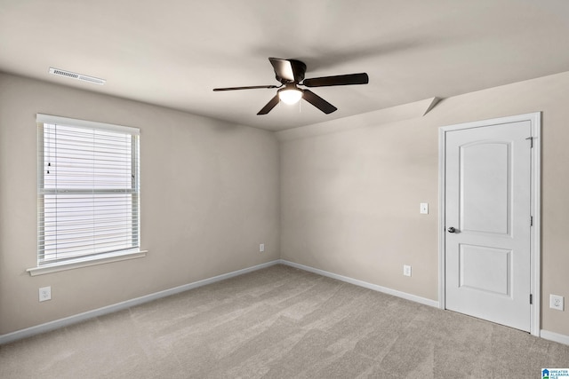 spare room with visible vents, baseboards, a ceiling fan, and carpet floors
