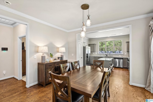dining area featuring dark wood-style flooring, ornamental molding, and baseboards