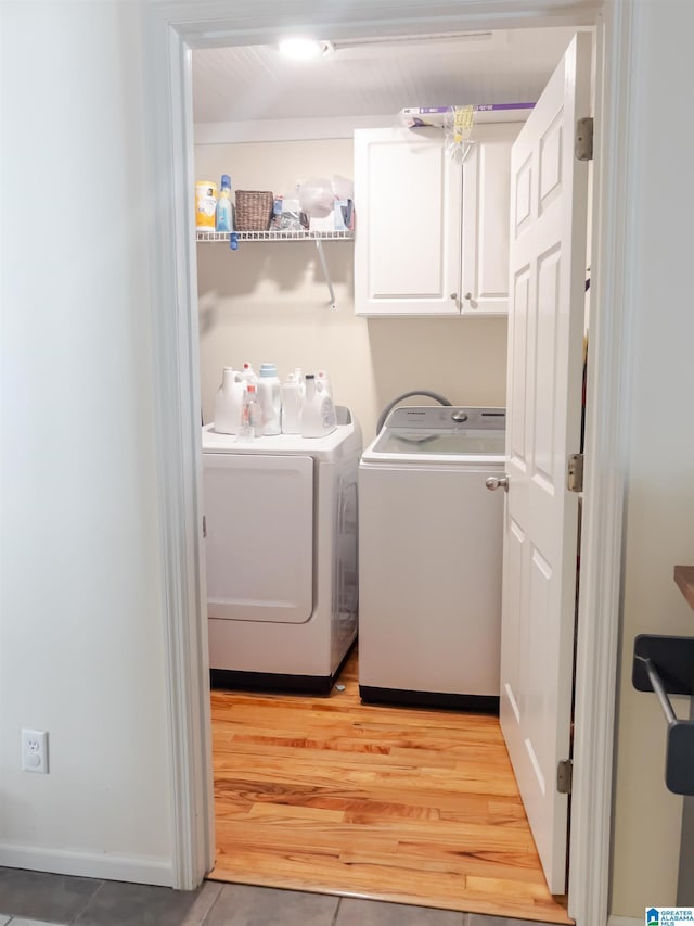 laundry room with separate washer and dryer, light wood finished floors, baseboards, and cabinet space