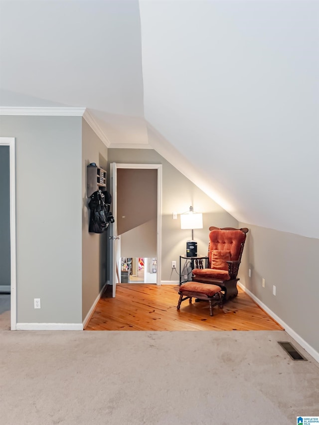 living area featuring ornamental molding, visible vents, baseboards, and carpet