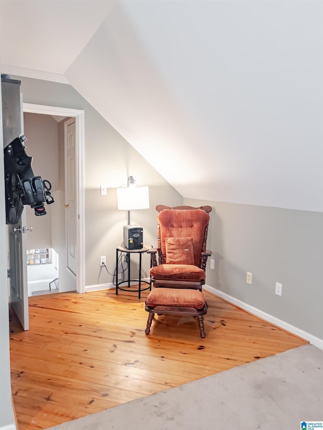sitting room with hardwood / wood-style flooring, baseboards, and lofted ceiling