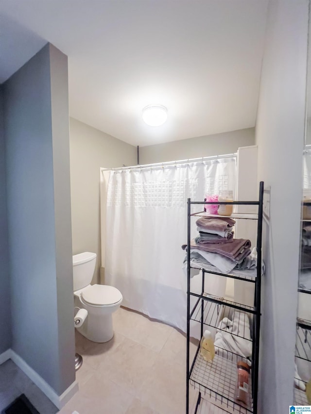 bathroom with toilet, curtained shower, and baseboards
