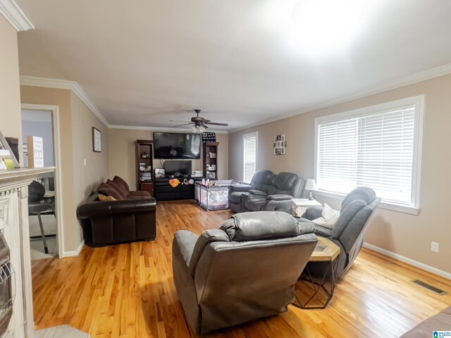 living room featuring light wood-style floors, a healthy amount of sunlight, and a ceiling fan