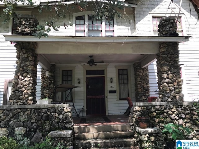 property entrance with a porch, a balcony, and a ceiling fan