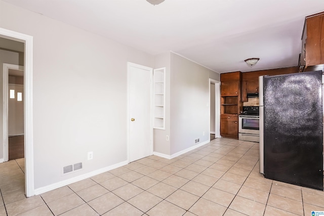 kitchen with visible vents, extractor fan, light tile patterned floors, and stainless steel appliances