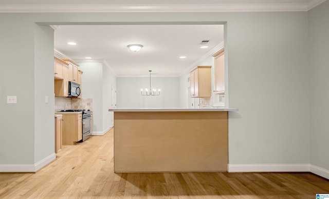 kitchen featuring crown molding, stainless steel range with gas stovetop, black microwave, a chandelier, and light wood finished floors
