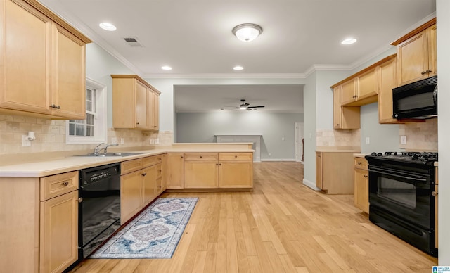 kitchen featuring a peninsula, light brown cabinetry, visible vents, black appliances, and a sink