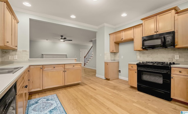 kitchen featuring crown molding, light wood-style flooring, a peninsula, black appliances, and light brown cabinets