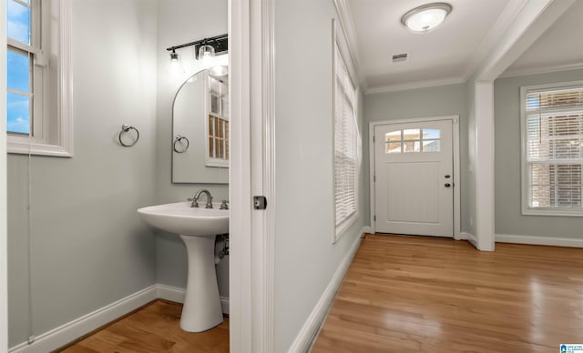 bathroom featuring crown molding, wood finished floors, baseboards, and visible vents