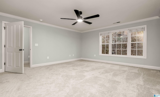 empty room featuring carpet flooring, visible vents, a ceiling fan, and crown molding