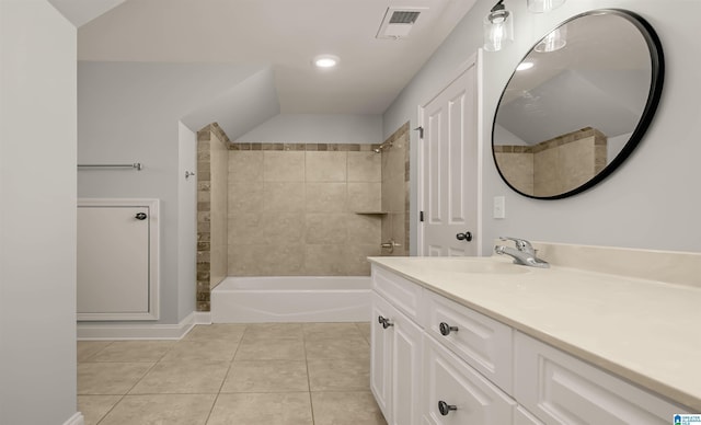 full bath with bathtub / shower combination, vanity, vaulted ceiling, visible vents, and tile patterned floors