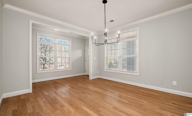 unfurnished dining area with an inviting chandelier, light wood-type flooring, ornamental molding, visible vents, and baseboards
