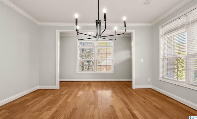 unfurnished dining area with crown molding, an inviting chandelier, baseboards, and light wood-type flooring