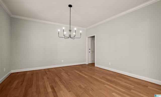 unfurnished dining area featuring crown molding, baseboards, light wood finished floors, and an inviting chandelier