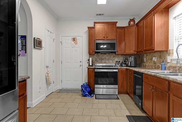 kitchen with visible vents, a sink, arched walkways, decorative backsplash, and appliances with stainless steel finishes