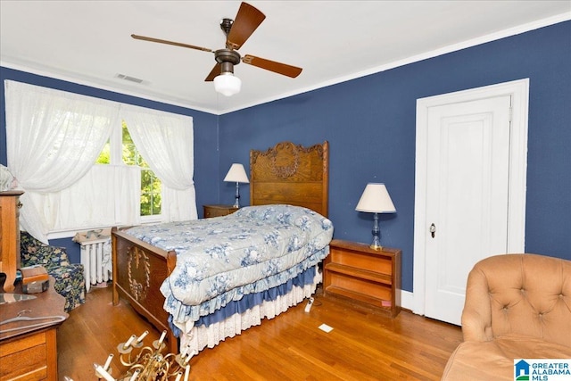 2701 21st St, Birmingham, AL 35208 - bedroom with baseboards, a ceiling fan, radiator heating unit, visible vents, and wood finished floors