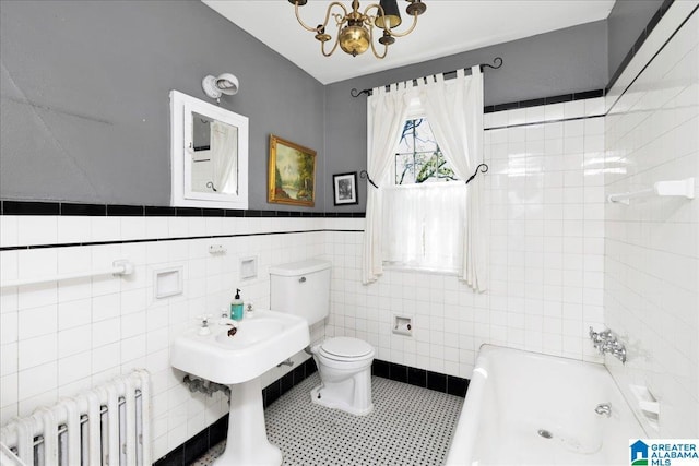 2701 21st St, Birmingham, AL 35208 - full bath with radiator heating unit, a chandelier, toilet, washtub / shower combination, and tile walls