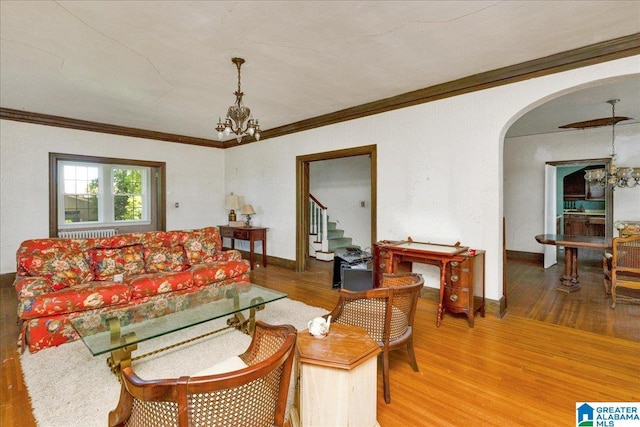 2701 21st St, Birmingham, AL 35208 - living area featuring baseboards, an inviting chandelier, radiator, arched walkways, and wood finished floors