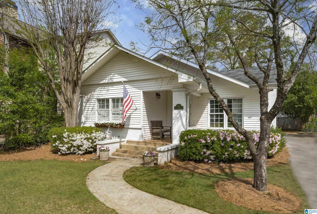 bungalow featuring a front lawn and a porch