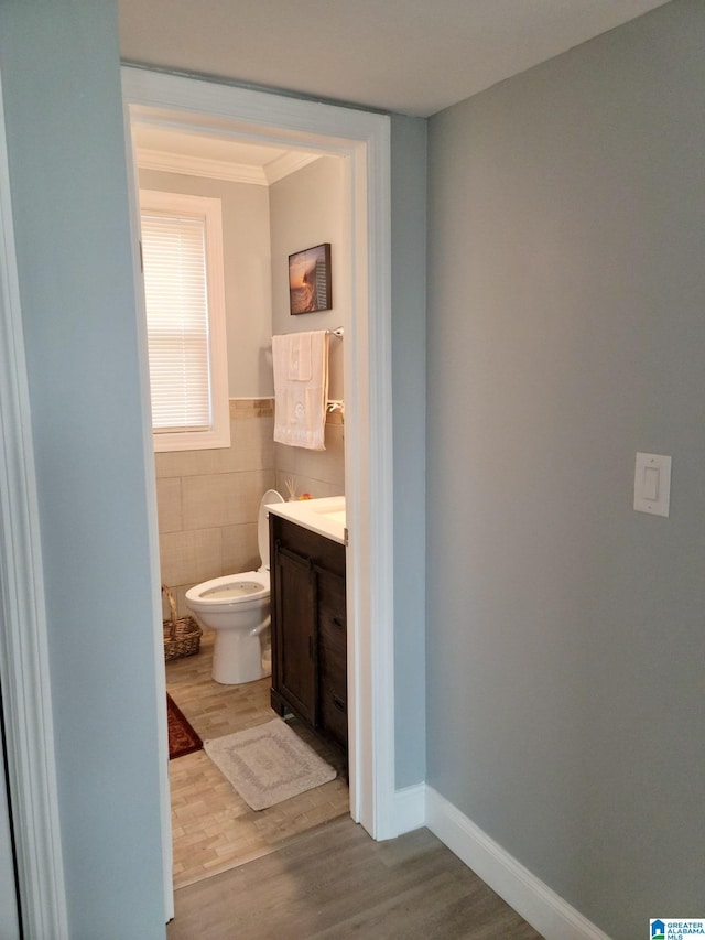 627 Sidney Cir, Anniston, AL 36207 - half bathroom featuring wood finished floors, toilet, vanity, tile walls, and crown molding