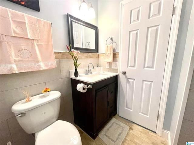 627 Sidney Cir, Anniston, AL 36207 - bathroom featuring tile walls, toilet, vanity, and wood finished floors