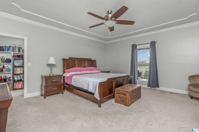 carpeted bedroom with baseboards, crown molding, a ceiling fan, and a textured ceiling