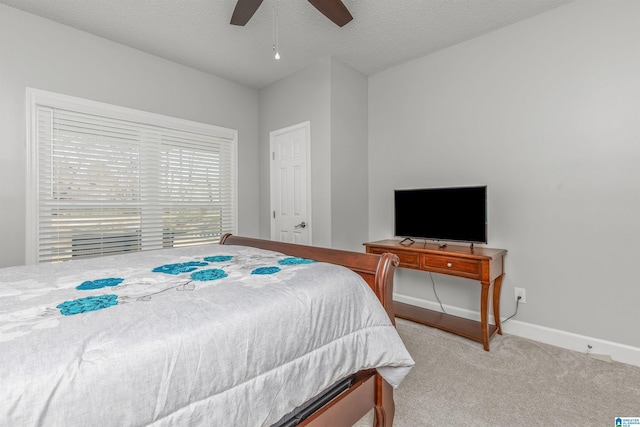 bedroom featuring baseboards, ceiling fan, carpet, and a textured ceiling