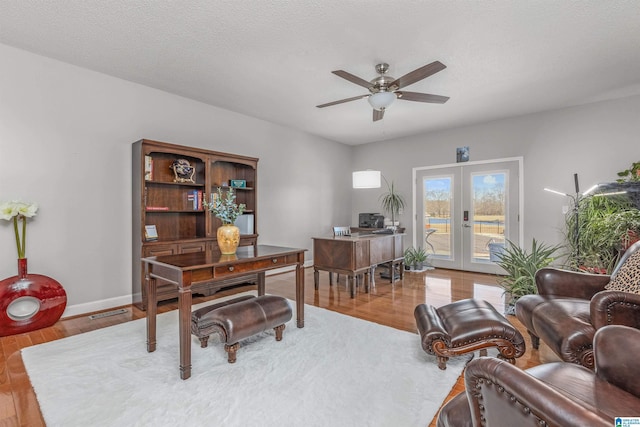 office space featuring french doors, ceiling fan, baseboards, and wood finished floors