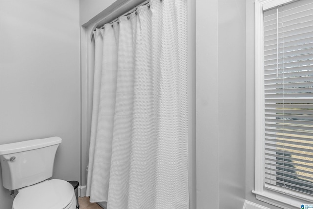 full bath with toilet and a shower with curtain