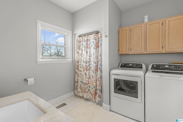 clothes washing area with light tile patterned floors, visible vents, a sink, cabinet space, and washing machine and dryer