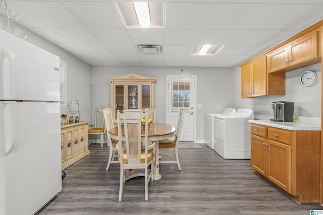 interior space featuring light countertops, freestanding refrigerator, visible vents, dark wood finished floors, and washer and dryer