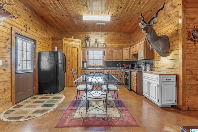 kitchen featuring wooden ceiling, a sink, wooden walls, black appliances, and finished concrete floors