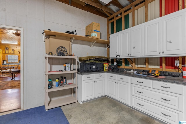 kitchen with concrete flooring, white cabinets, and open shelves