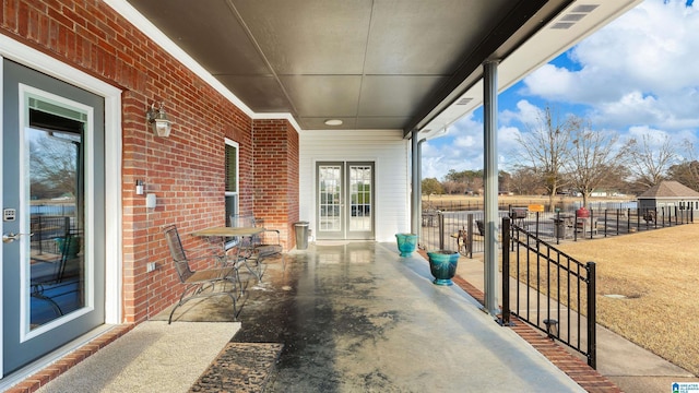 view of patio with french doors and fence