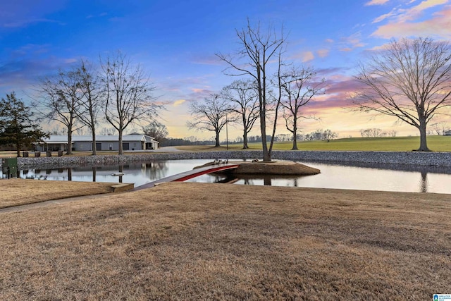 dock area with a water view and a lawn