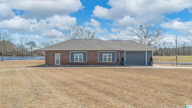 single story home with a front yard, an attached garage, concrete driveway, brick siding, and roof with shingles