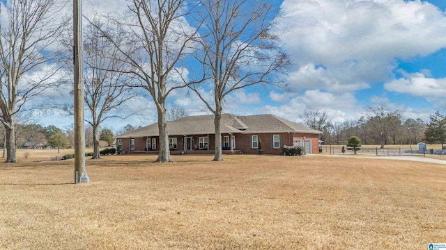 single story home featuring a garage, brick siding, and a front lawn