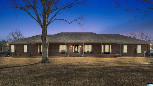 rear view of house with brick siding and a shingled roof