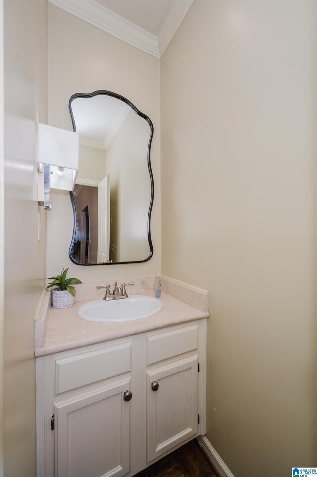 bathroom with crown molding, baseboards, vanity, and wood finished floors