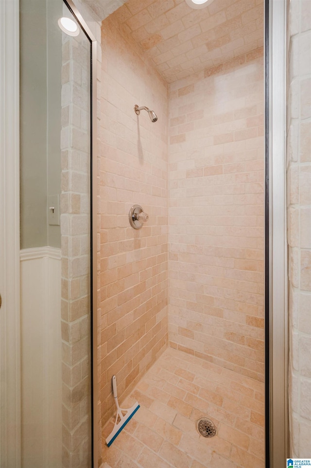 bathroom featuring a stall shower and wainscoting